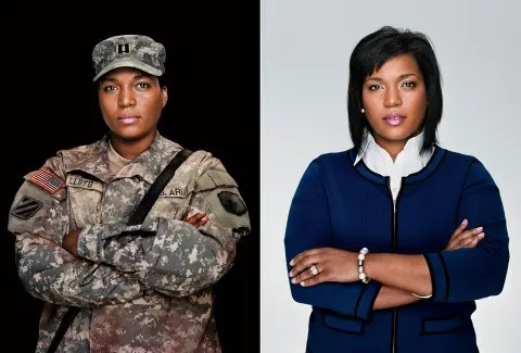 Two women in military uniforms and one woman is standing up.